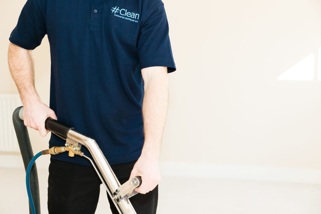 Professional office cleaning team carrying out desk and floor cleaning in a modern workspace