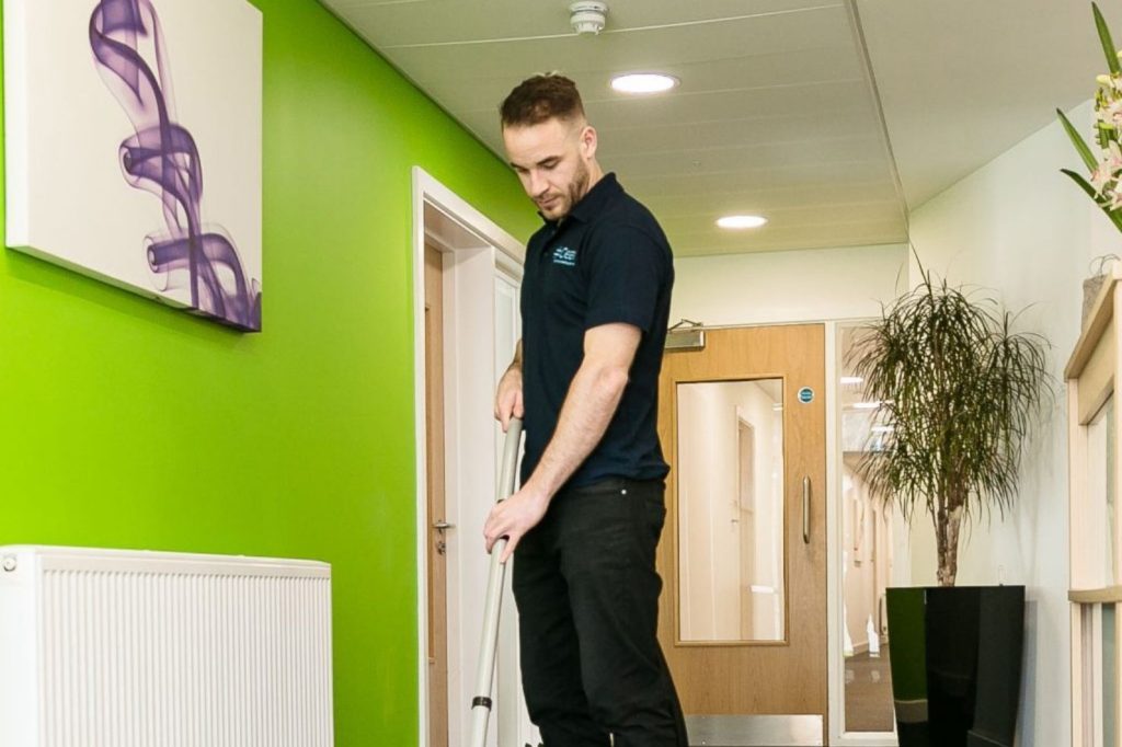 Professional Office Cleaning service vacuuming office hallway with professional equipment