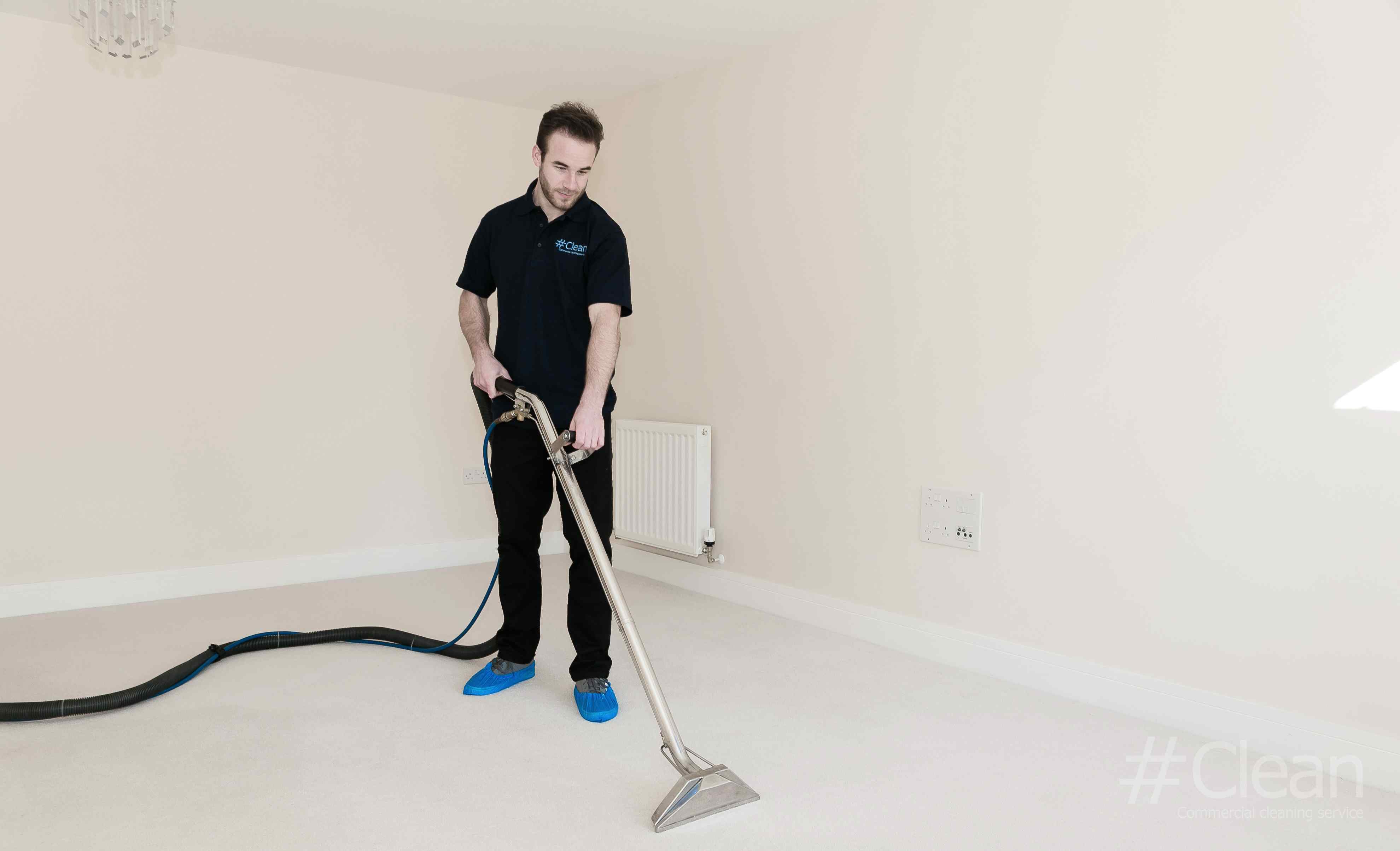 Man In Hashtag Clean Uniform Cleaning A Carpet